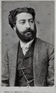 Une image contenant Visage humain, habits, portrait, Barbe humaine Description générée automatiquement